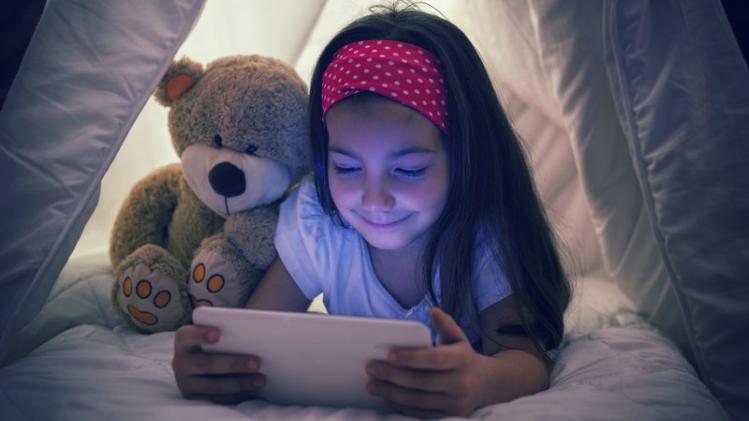 Little Girl Using Digital Tablet in Bed