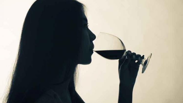Silhouette shot of a female drinking red wine.