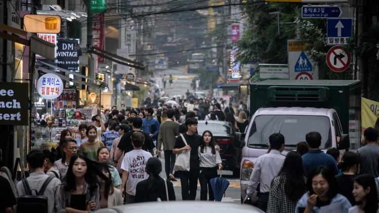 Shoppers_walk_along_a_street_in_a_shopping_district_of_Seoul_on_June_6_2019_6e6c