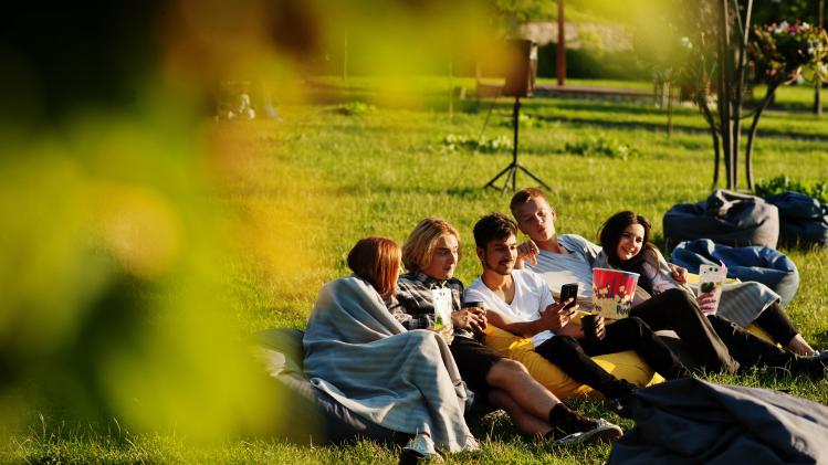 jeune-groupe-multiethnique-personnes-regardant-film-au-pouf-dans-cinema-plein-ai