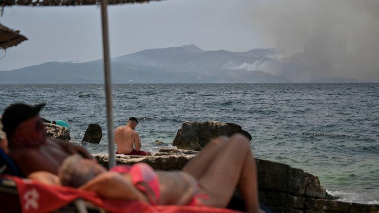 People_sunbath_near_the_coastal_town_of_Saranda_as_smoke_billows_from_the_Greek_