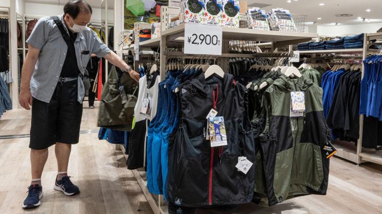 This_photo_taken_on_August_7_2023_shows_a_shopper_looking_at_jackets_designed_to