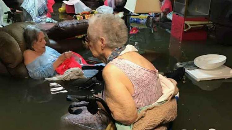 Bejaarden zitten tot hun middel in het water door storm Harvey