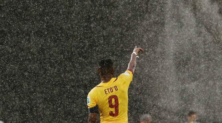 cameroons-samuel-etoo-points-to-his-teammate-as-the-rain-pours-down-in-natal.jpg
